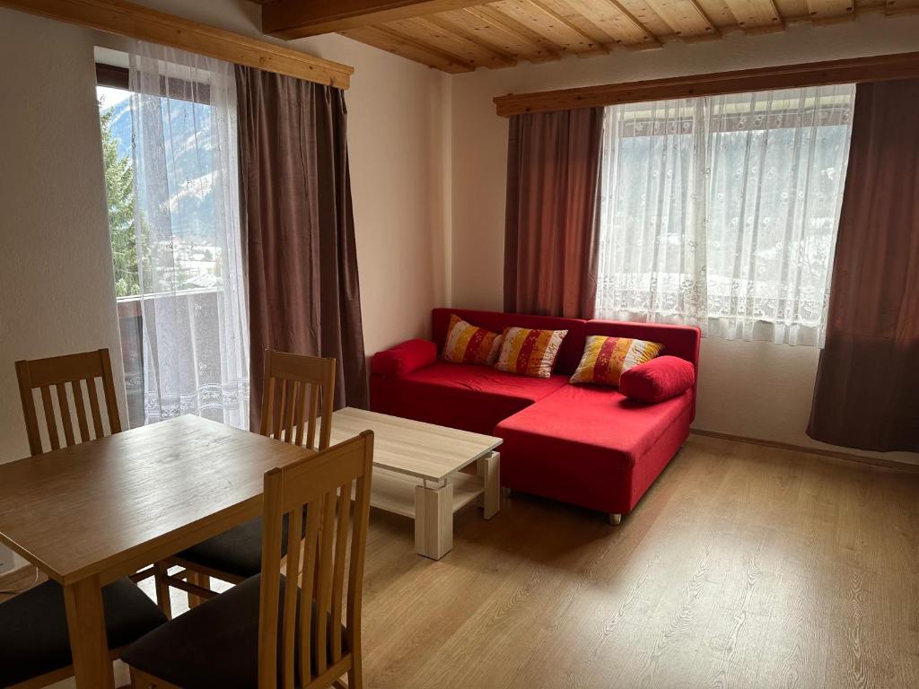 Appartement mit rotem Sofa und Essbereich